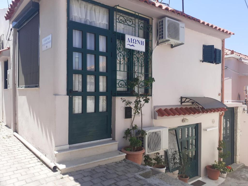 un edificio con una puerta verde y un cartel en él en Μεζονέτα - Διώνη- στις Άνω Αρχάνες με οντά en Archanes