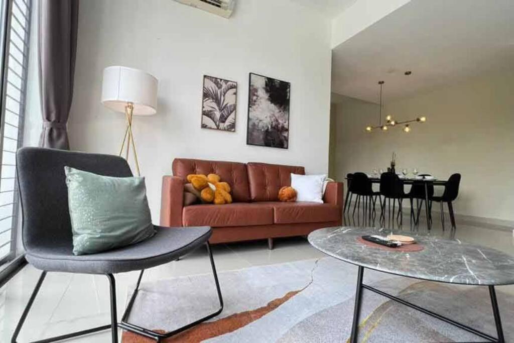 a living room with a red couch and a table at Spacious Townvilla - 10pax in Puchong