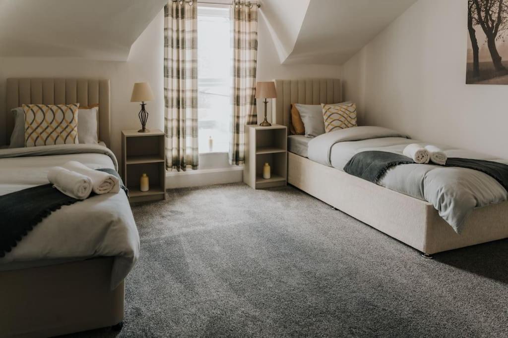 um quarto com 2 camas e uma janela em Alice - spacious 3 bedroom house contractor accommodation em Sunderland