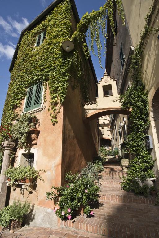 an ivycovered building with a staircase in front of it at La Casetta Di Borgo in Lajatico