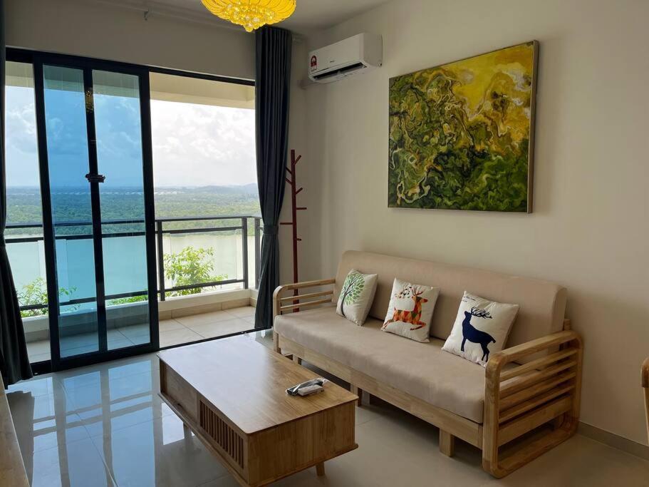 uma sala de estar com um sofá e uma mesa em Forest city Sea view homestay em Gelang Patah