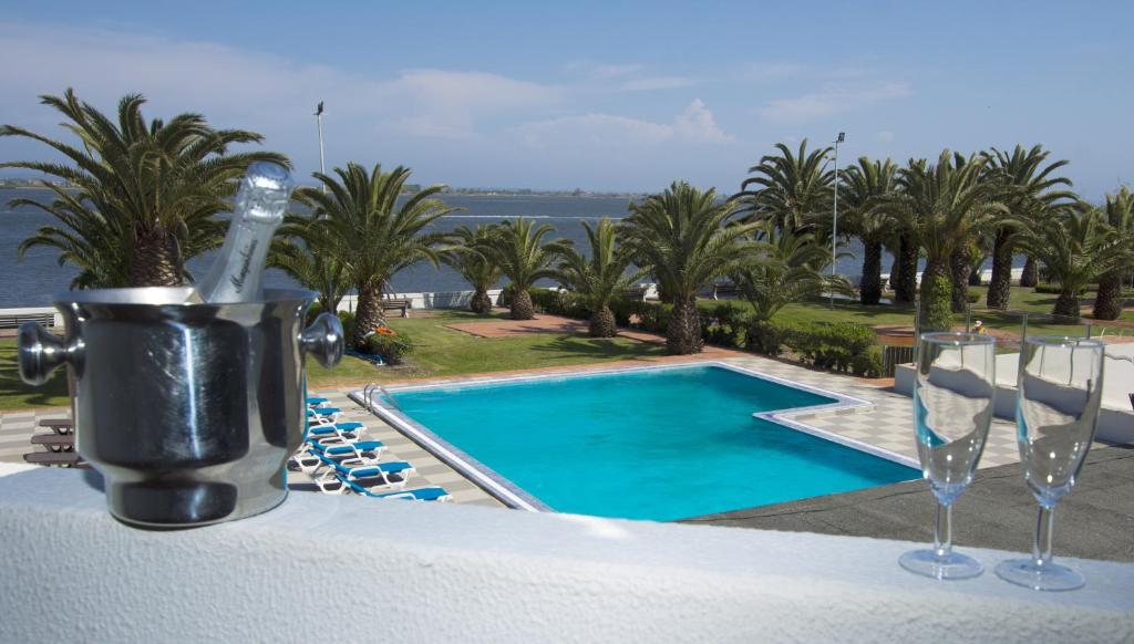 uitzicht op een zwembad met wijnglazen bij Riabela Inn in Torreira