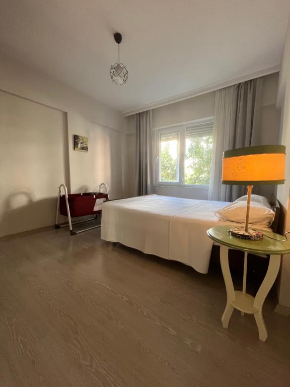 安塔利亞的住宿－Large and Simple Family House in Antalya Center，一间卧室配有一张床和一张带台灯的桌子