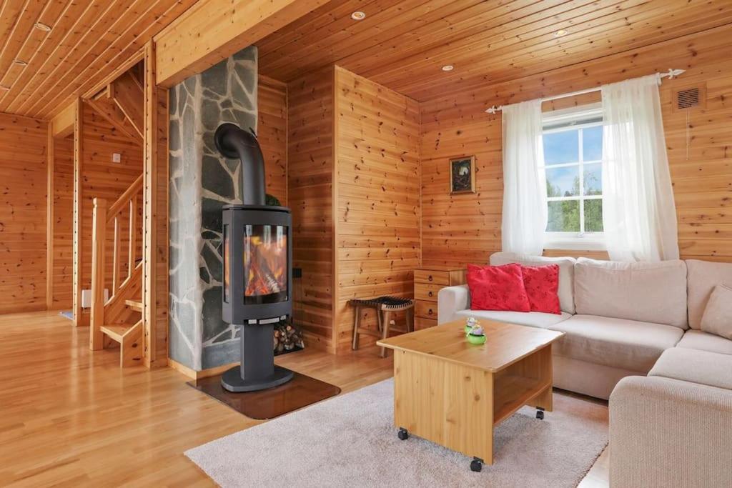 a living room with a fireplace in a log cabin at Hytte i flott natur in Alta