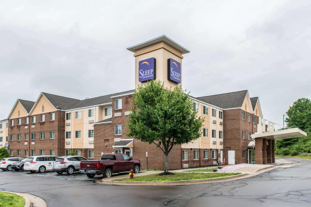 a building with a sign on it in a parking lot at Sleep Inn & Suites Pittsburgh Airport in Imperial