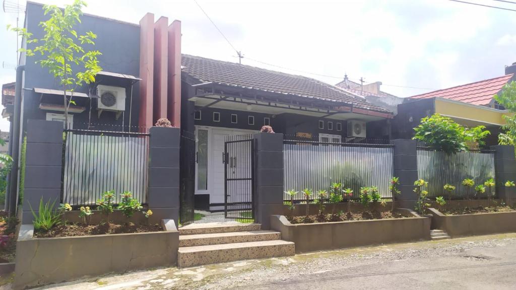 a house with a gate and some plants at Endah Homestay Syariah in Purwokerto