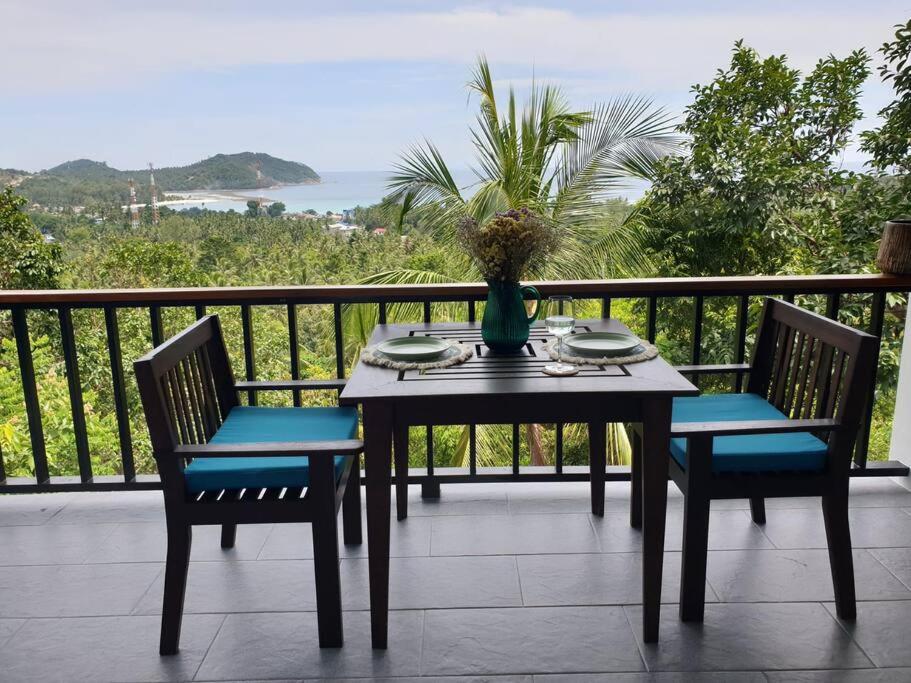 un tavolo e sedie su un balcone con vista sull'oceano di The Love Nest - Stylish One Bed House a Ban Chalok Lam