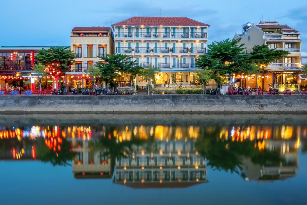 a group of buildings next to a body of water at Lantana Boutique Hoi An Hotel in Hoi An