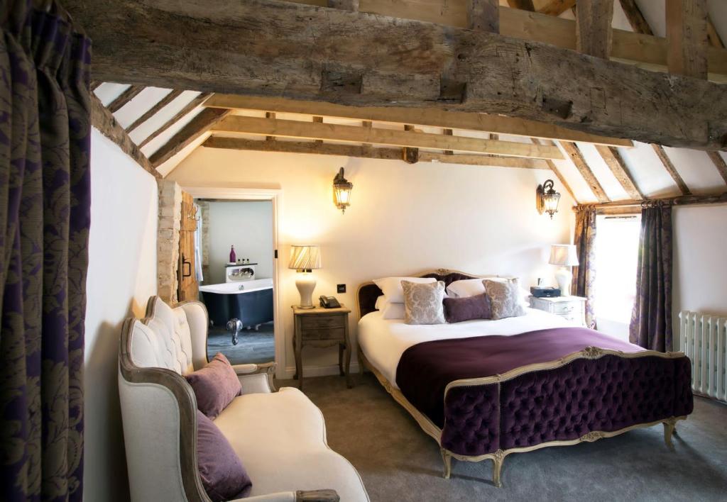 a bedroom with a king sized bed and a chair at The White Hart Hotel in Hingham