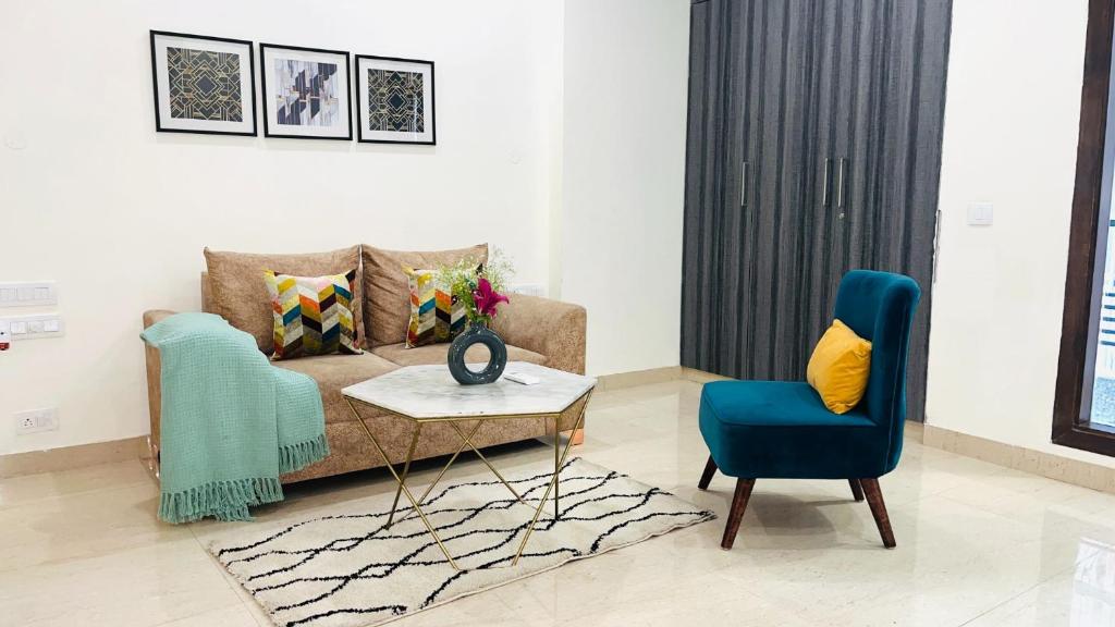 uma sala de estar com um sofá, uma mesa e uma cadeira em BluO 1BHK - DLF CyberCity, Balcony, Lift, Parking em Gurgaon