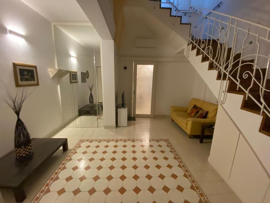 ein Wohnzimmer mit einer Treppe und einer gelben Couch in der Unterkunft Casa Vacanze Zia Meme in San Donato di Lecce
