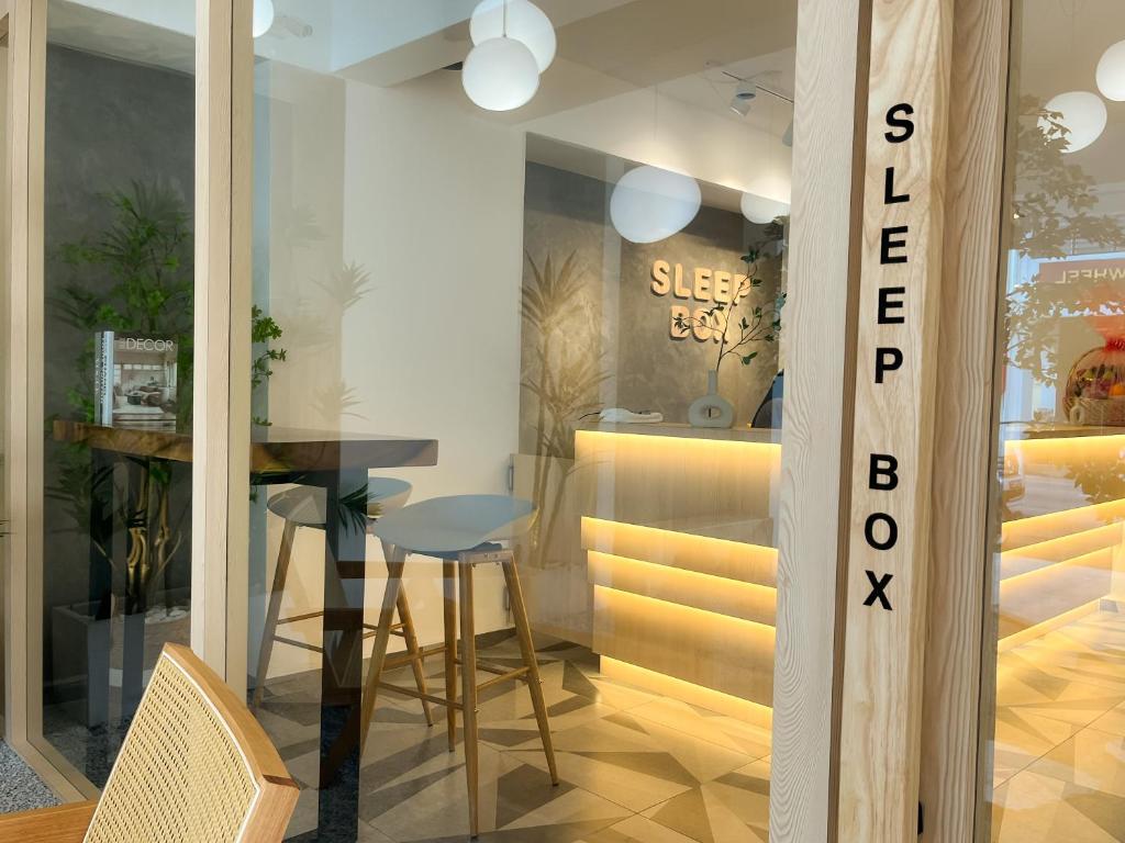 ein Esszimmer mit einem Tisch und einem Glasfenster in der Unterkunft Sleep Box Penang in George Town