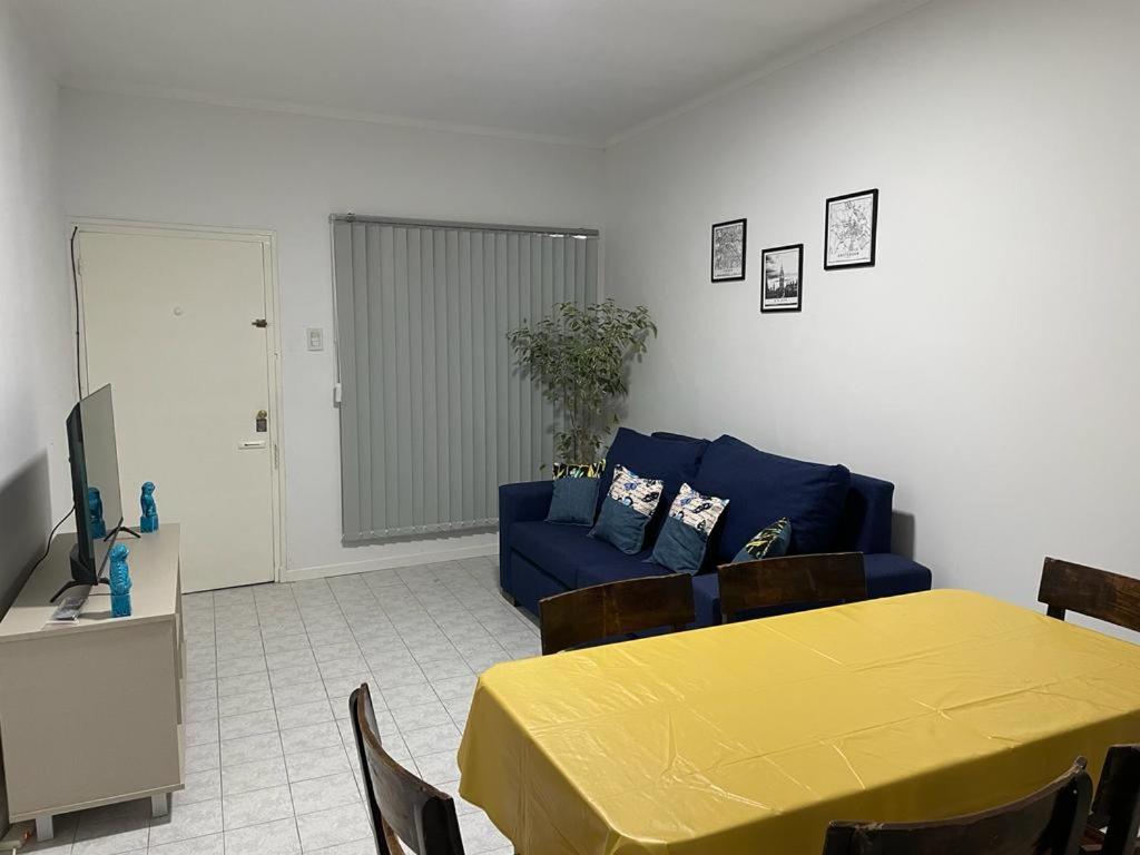 een woonkamer met een blauwe bank en een tafel bij Patio! Parrilla! Cochera! 2 habitaciones in Godoy Cruz