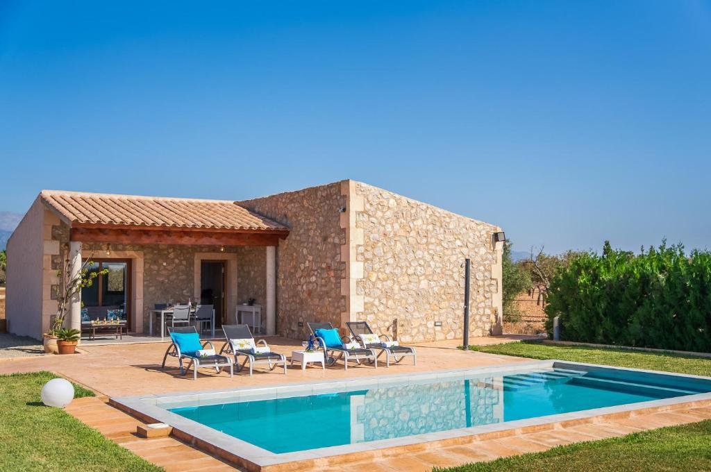 a villa with a swimming pool in front of a house at El Rafal de Son Alberti in Búger