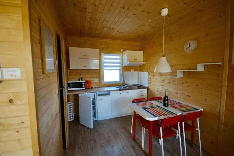 a kitchen with a table and chairs in a cabin at Leisure complex with a swimming pool Jezierzany in Jezierzany