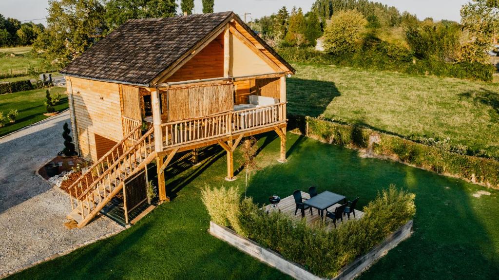 - une vue aérienne sur une cabane en rondins avec une piscine d'eau dans l'établissement Ô Sparadis Maroilles, à Maroilles