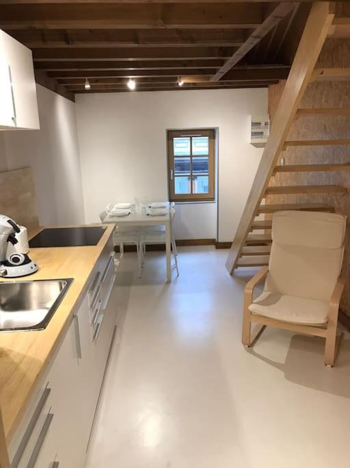 uma cozinha com uma escada, uma mesa e uma cadeira em Studio 30m2 centre de Cusset em Cusset