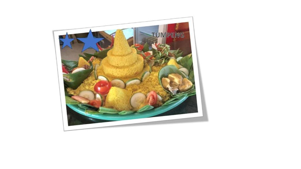 a picture of a plate of food with a pyramid of fruit at Dawala Hotel in Sudiang