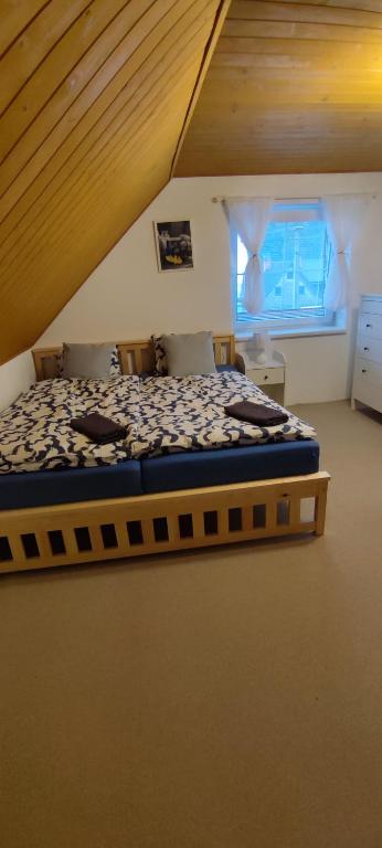 um quarto com uma cama grande num sótão em Chalupa v Oblacích em Jindřichov