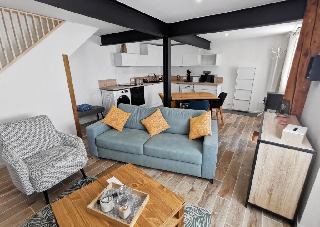 un salon avec un canapé bleu et une table dans l'établissement Les remparts de Caroline, au pied de La Cité., à Carcassonne