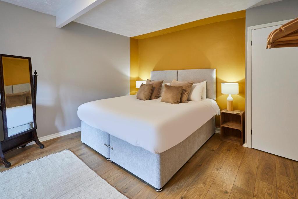 a bedroom with a large bed and a yellow wall at Host & Stay - Stone Row in Skinningrove