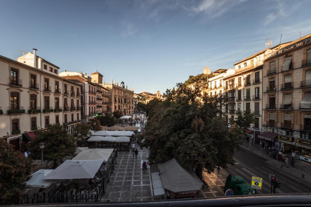 a city street with a group of tables and buildings at El balcón de la vela in Granada