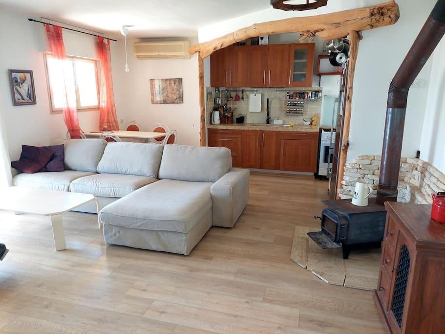 een woonkamer met een witte bank en een keuken bij מצפה 1050 in Neve Ativ