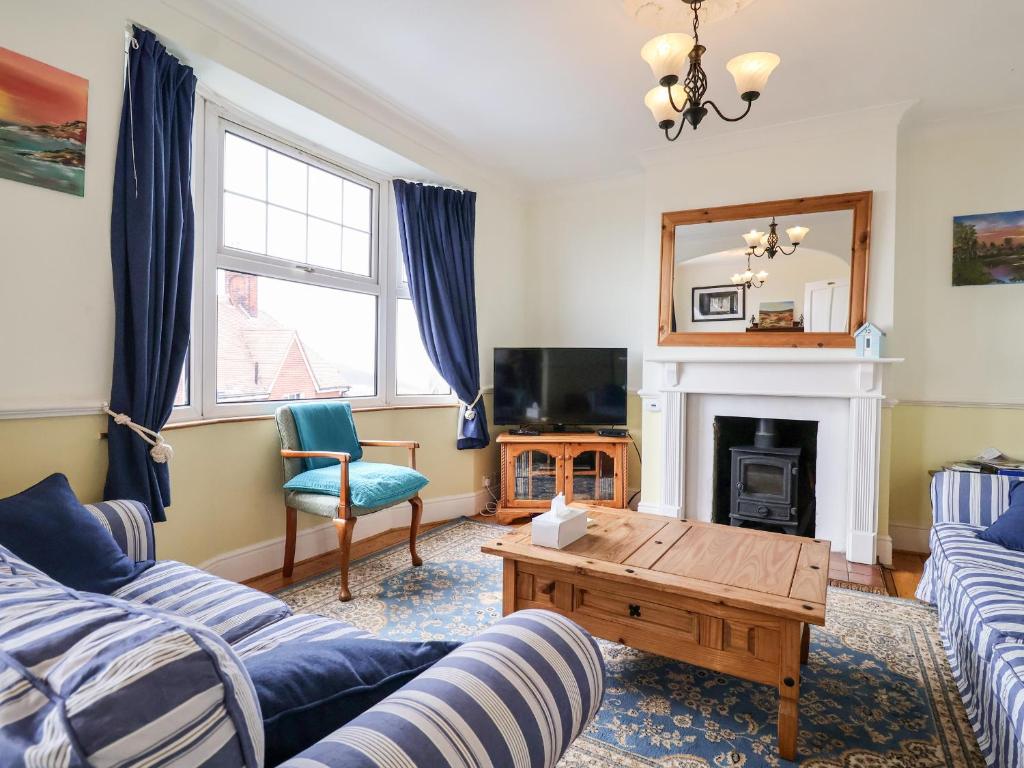 uma sala de estar com dois sofás e uma lareira em The Pink House em Felixstowe