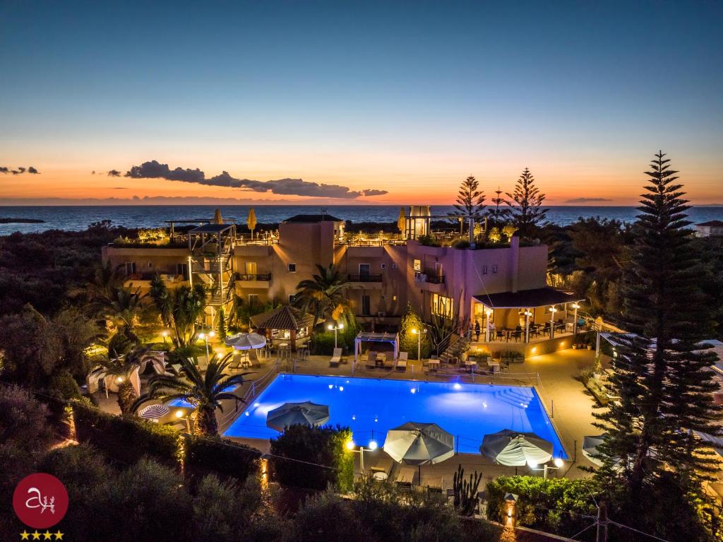 una vista aerea di un resort con piscina di notte di Apollo Resort Art Hotel a Kyparissia