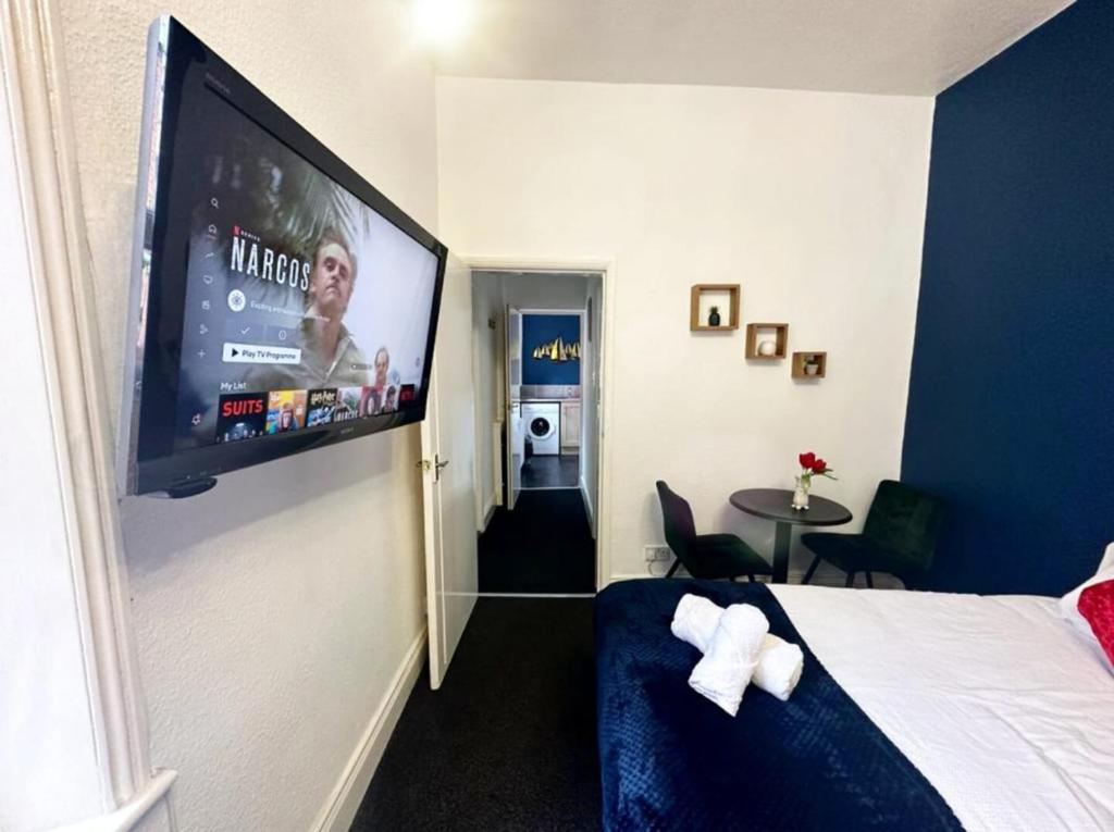 Habitación de hotel con TV de pantalla plana en la pared en A&A Luxury Stay Bettys en Pallion