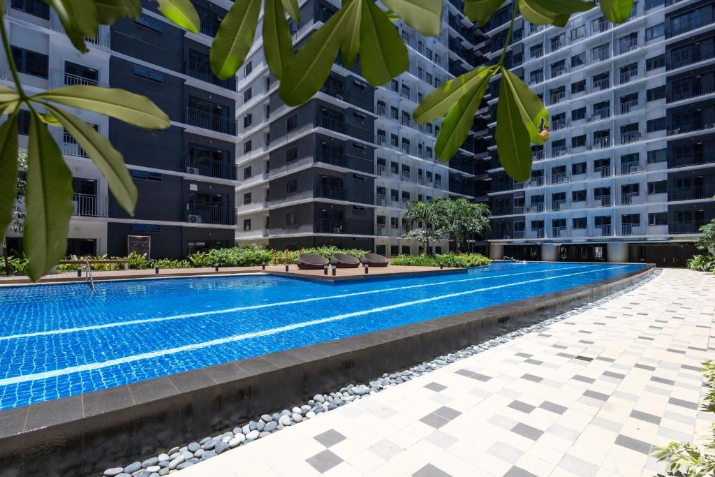 a swimming pool in a building with tall buildings at Shore 3 Residences, Mall of Asia Complex in Manila