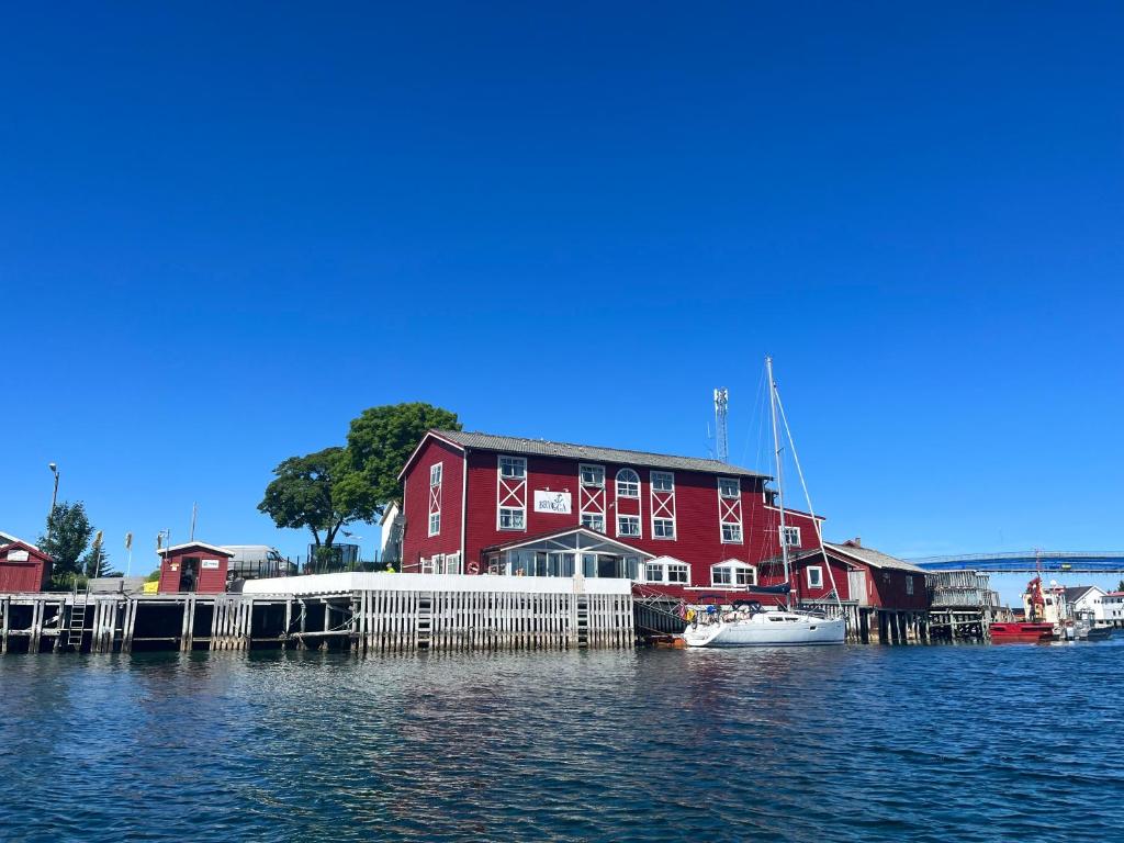 a red building with a marina with boats in the water at Herøy Brygge 