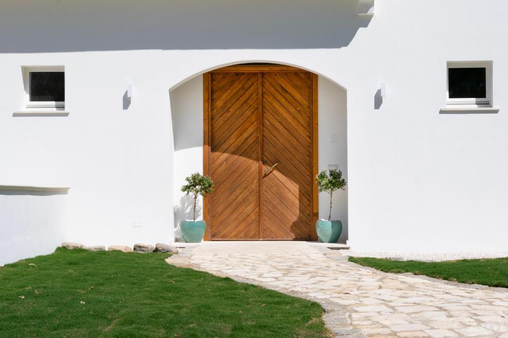 a wooden door on the side of a white building at Sa Pasadina in Àrbatax