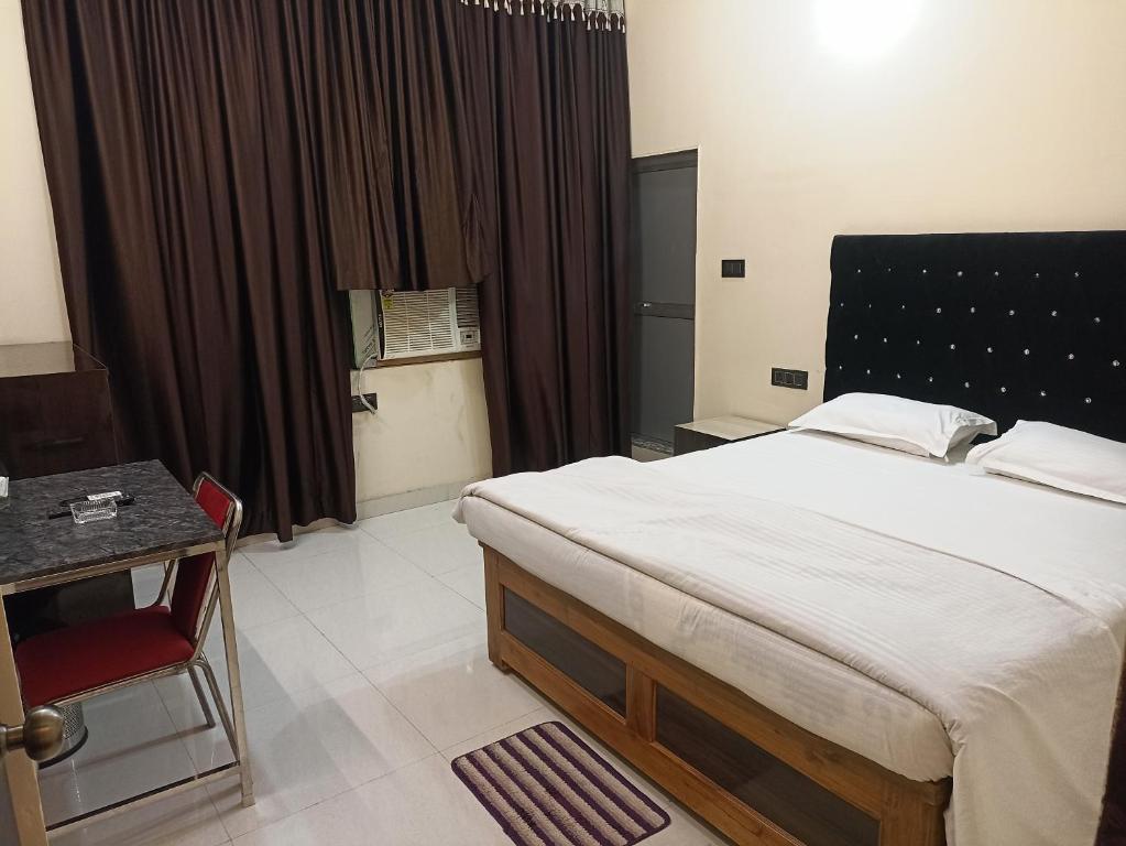 - une chambre avec un lit, une table et une fenêtre dans l'établissement Anand Vihar, à Jamshedpur