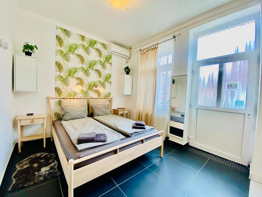 ein Schlafzimmer mit einem Bett und einem großen Fenster in der Unterkunft Green Skyline - Central studio with stunning view in Budapest