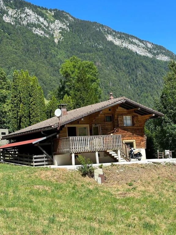 une cabane en rondins avec une terrasse couverte et une montagne dans l'établissement Chalet Flobelle, à Entremont