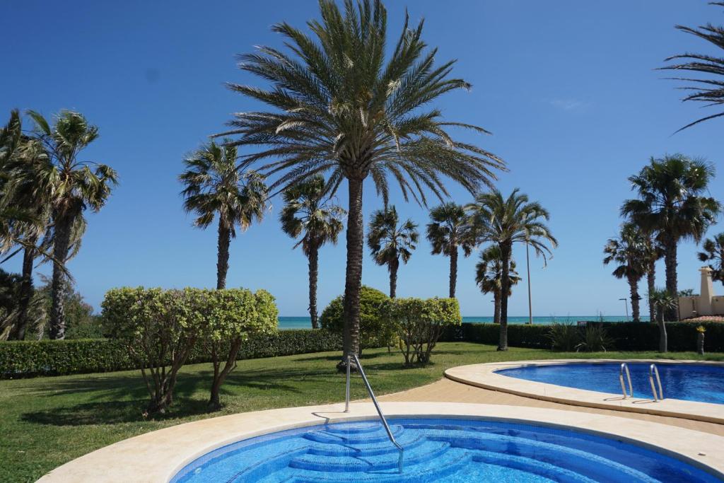 ein Pool mit Palmen im Hintergrund in der Unterkunft Estrella del Mar II in Denia