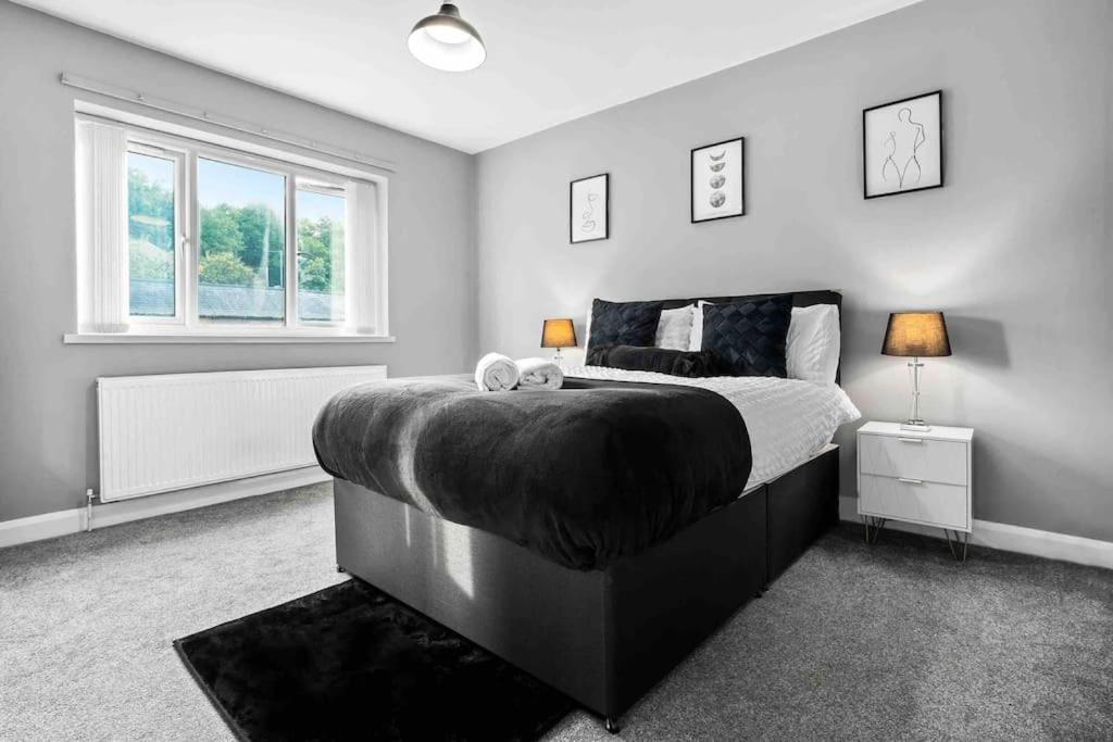 um quarto com uma cama grande e uma janela em Showcase Estates em Birmingham