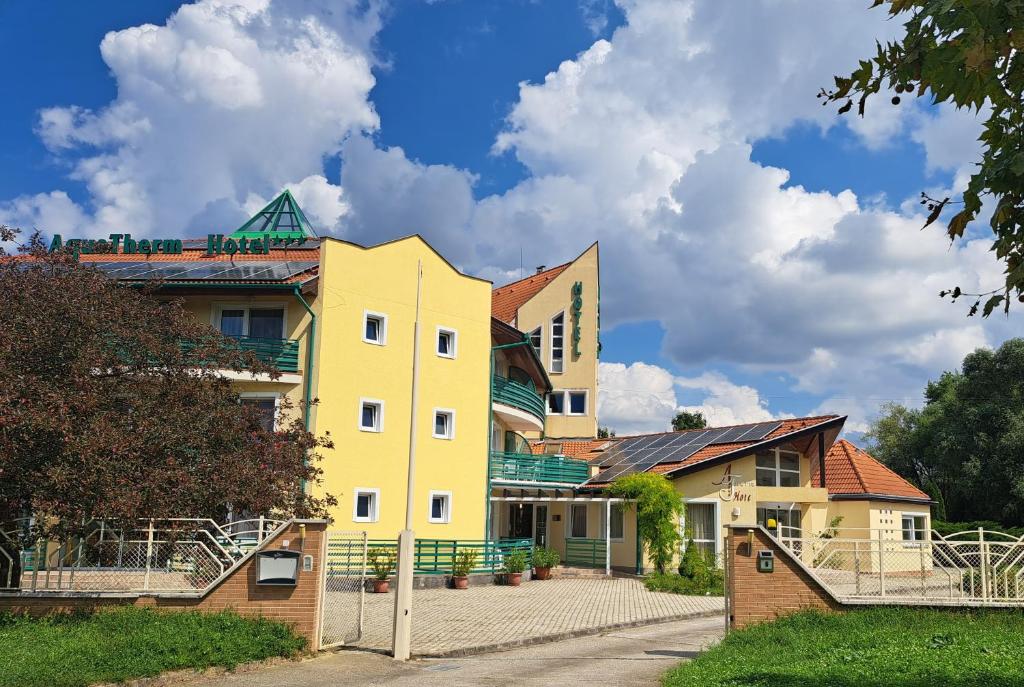 un edificio amarillo al lado de una calle en Aqua Therm Hotel, en Zalakaros