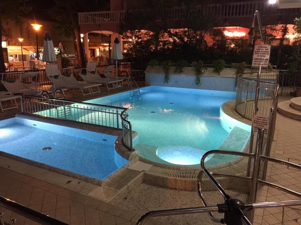 a large swimming pool at a hotel at night at Hotel Villa Verde in San Mauro a Mare