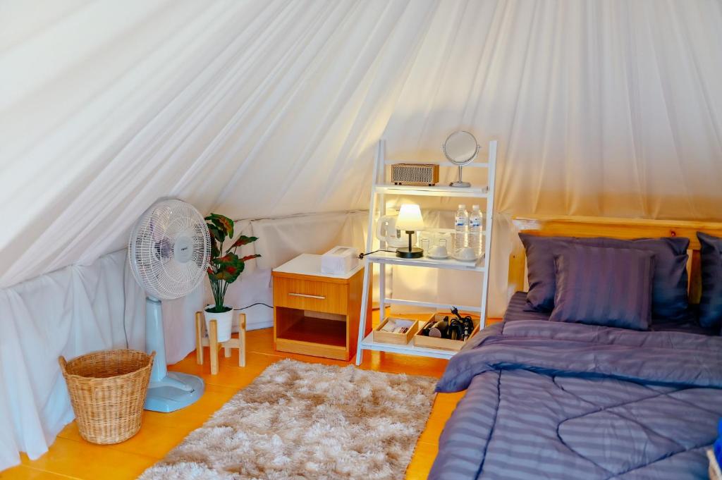 Schlafzimmer mit einem Bett, einem Ventilator und einem Schreibtisch in der Unterkunft ภูสกาย โฮมสเตย์ in Mon Jam
