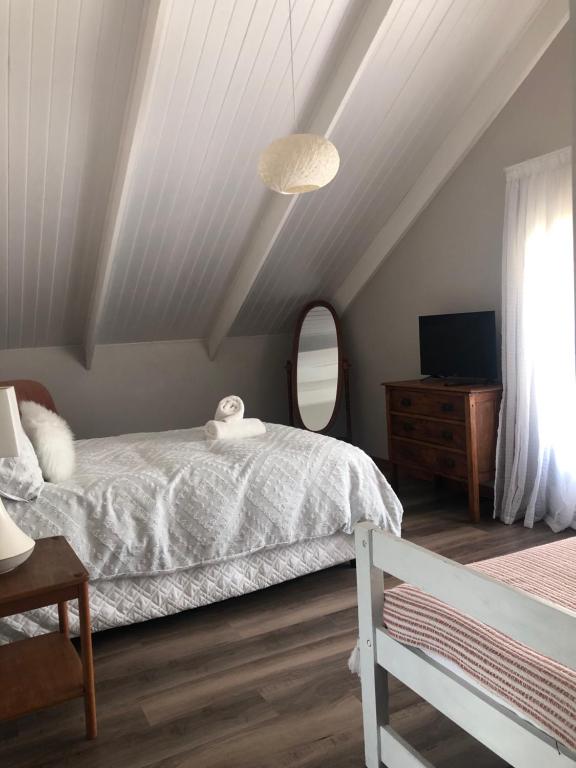 a bedroom with a white bed and a mirror at Loft on Honey in Sunridge Park