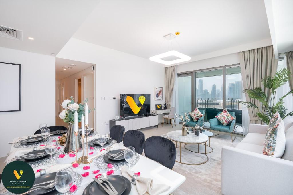 een witte woonkamer met een tafel en stoelen bij Vogue Downtown Views ll - Burj Khalifa View near Dubai Mall in Dubai