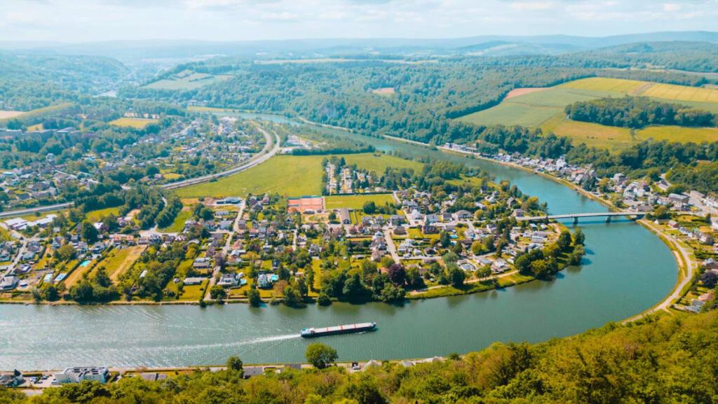 an aerial view of a town next to a river at LES 7 MEUSES - Restaurant & Hébergements HÔTELIERS - INSOLITES - WELLNESS - GÎTES in Profondeville