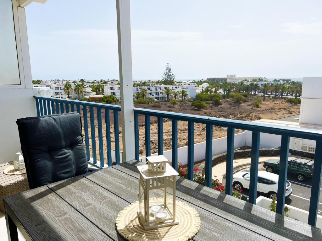 a table and chair on a balcony with a view of a street at LOS CHARCOS TERRACE VIEW in Costa Teguise