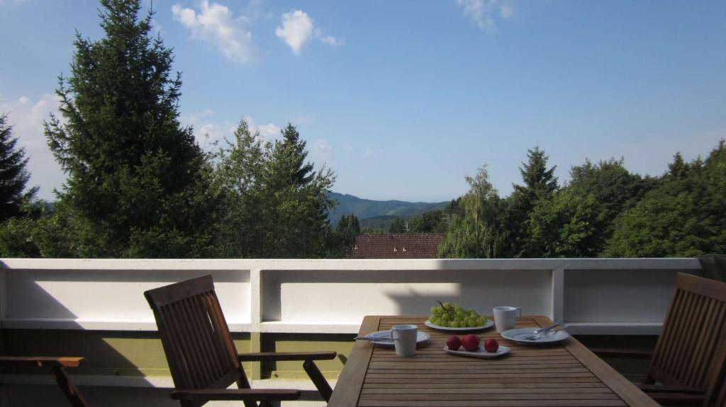 una mesa y sillas en un balcón con vistas en Ferienwohnung 11 mit Aussicht und Kamin, en Sankt Andreasberg