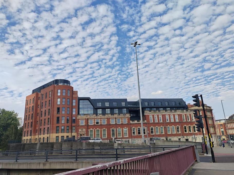 a large brick building with a sky with clouds at Central Leeds modern 1bed apartment in Leeds