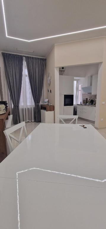 un soggiorno con tavolo e sedie bianchi di La Dimora di Parthenope a Napoli