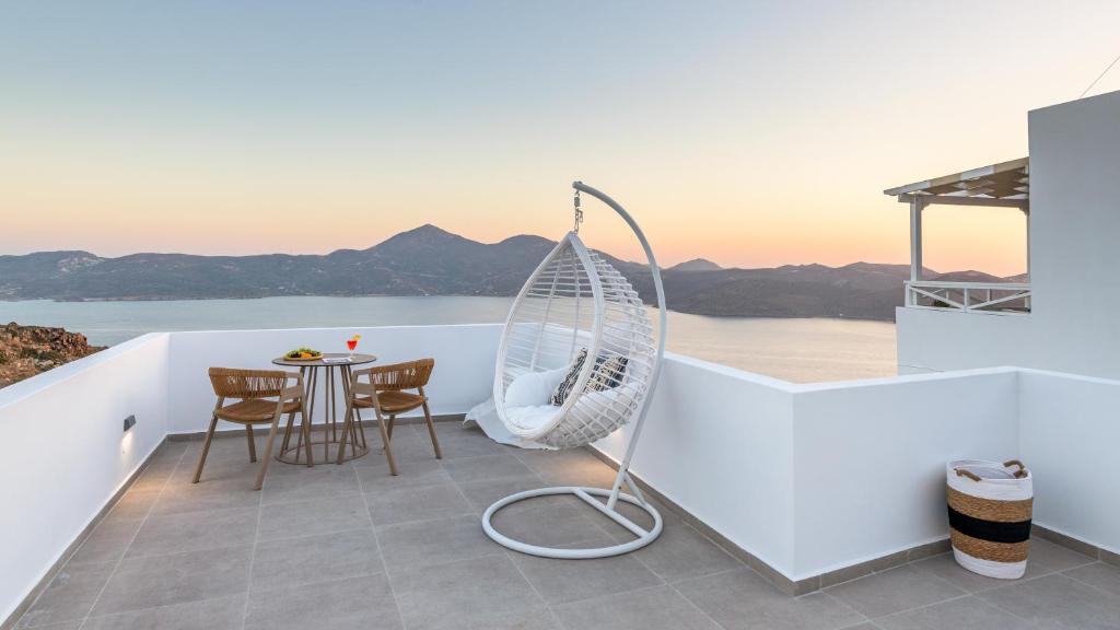 a swing on the balcony of a house with a table at Studios Betty in Plaka Milou