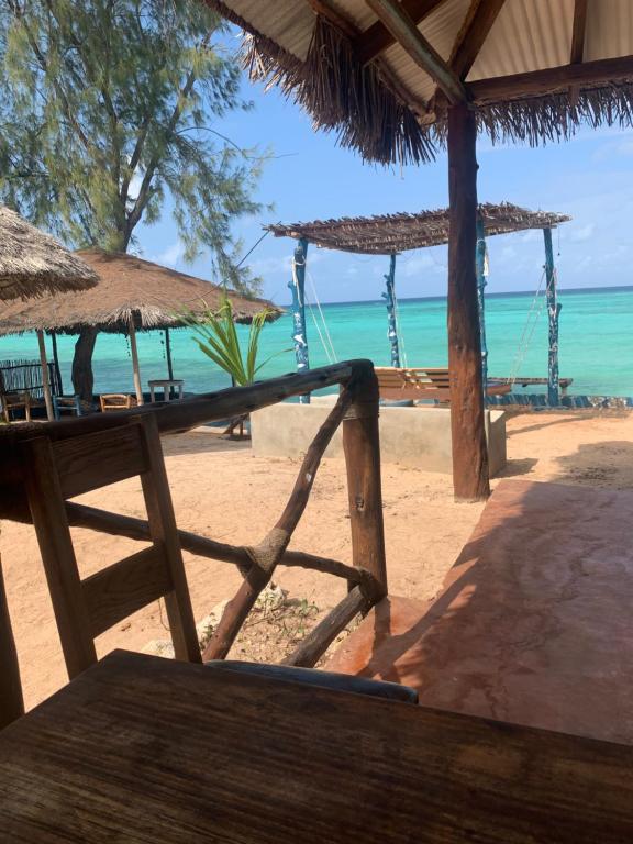 una playa con mesas y sombrillas y el océano en Tayana place en Kizimkazi